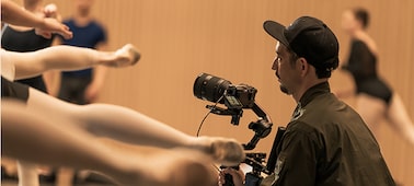 Imagen de uso en la que se muestra un fotógrafo que hace capturas en un ensayo de ballet con una cámara montada en un estabilizador