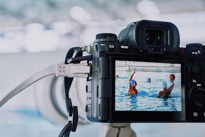 Imagen de uso de la cámara montada en un trípode y conectada a un cable LAN que hace capturas a un partido de waterpolo con una imagen Live View que se muestra en el monitor LCD