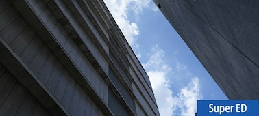 Imagen de ejemplo en la que se muestra el cielo y las nubes entre dos edificios altos y oscuros