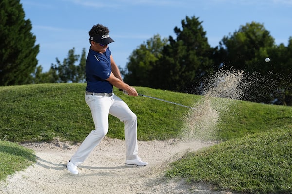 Imagen de ejemplo de un golfista realizando un golpe desde el búnker, momentos después de que el palo golpee la bola