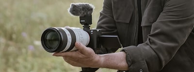 Imagen de uso de un hombre grabando un video de forma manual con un lente teleobjetivo acoplado